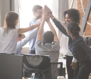 Team of people high fiving during a meeting